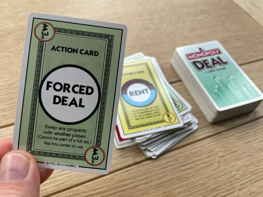 A player about to play the "Forced Deal" card in a game of Monopoly Deal