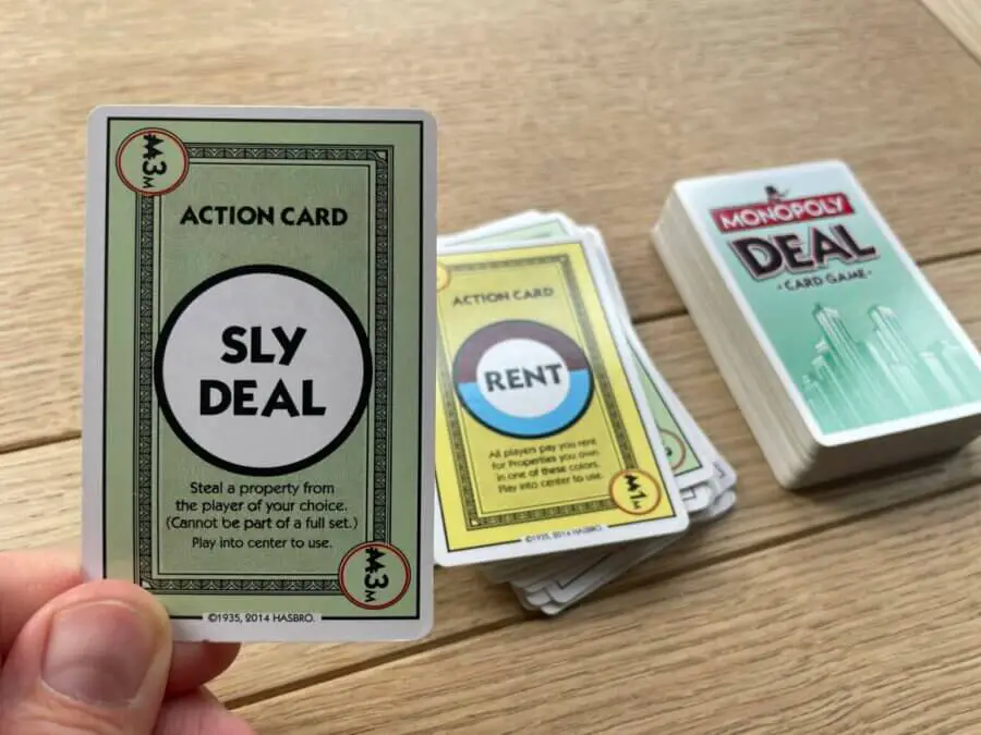 A player about to play the "Sly Deal" card in a game of Monopoly Deal