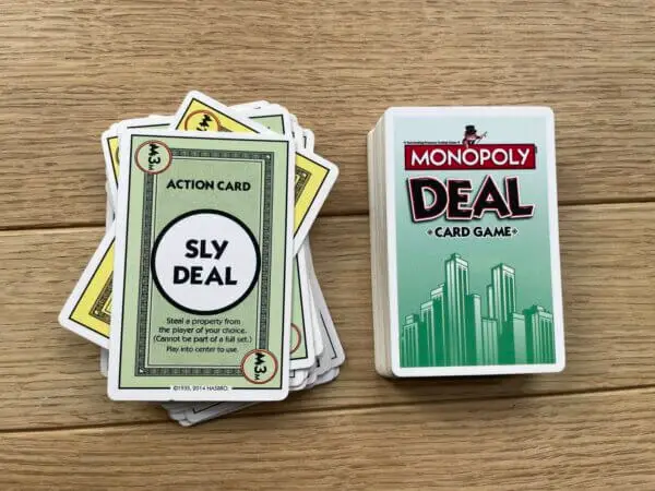 The "Sly Deal" card being actively played in a game of Monopoly Deal