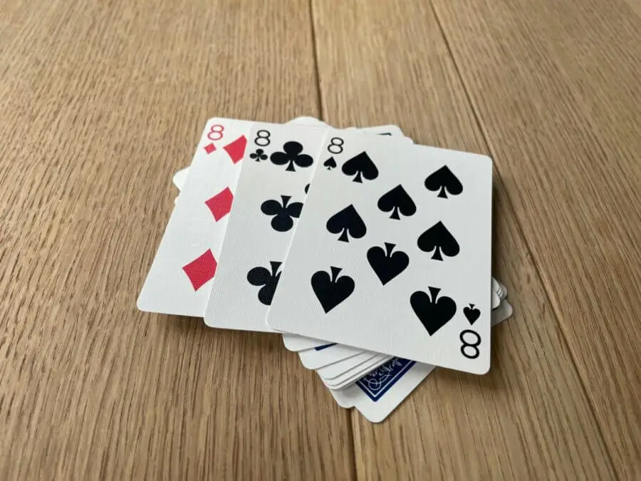 A set of three 8's revealed on a deck of cards
