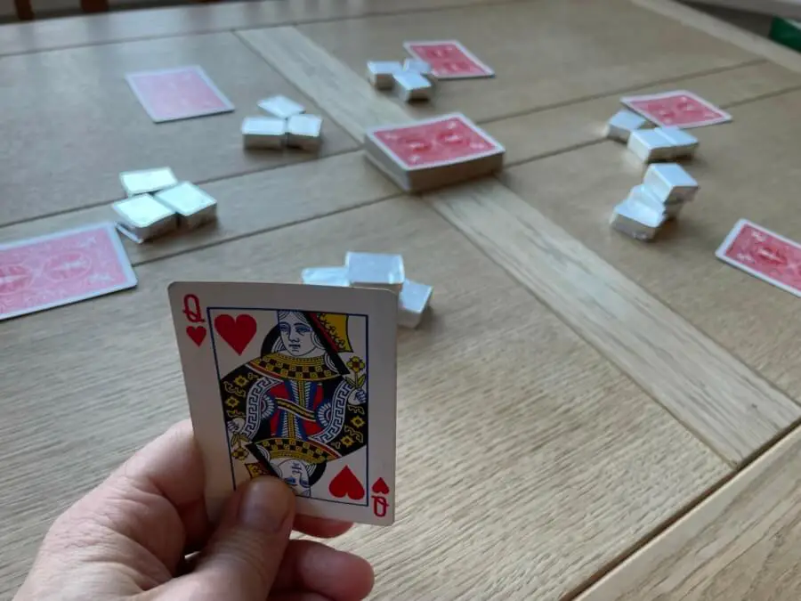The player reveals they are holding the Queen of Hearts
